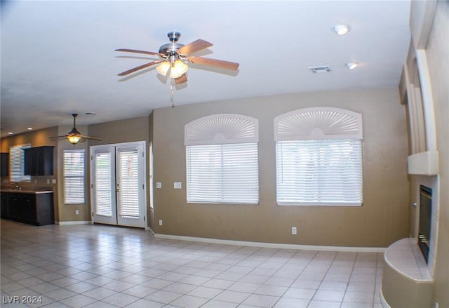 unfurnished living room featuring ceiling fan and light tile patterned floors