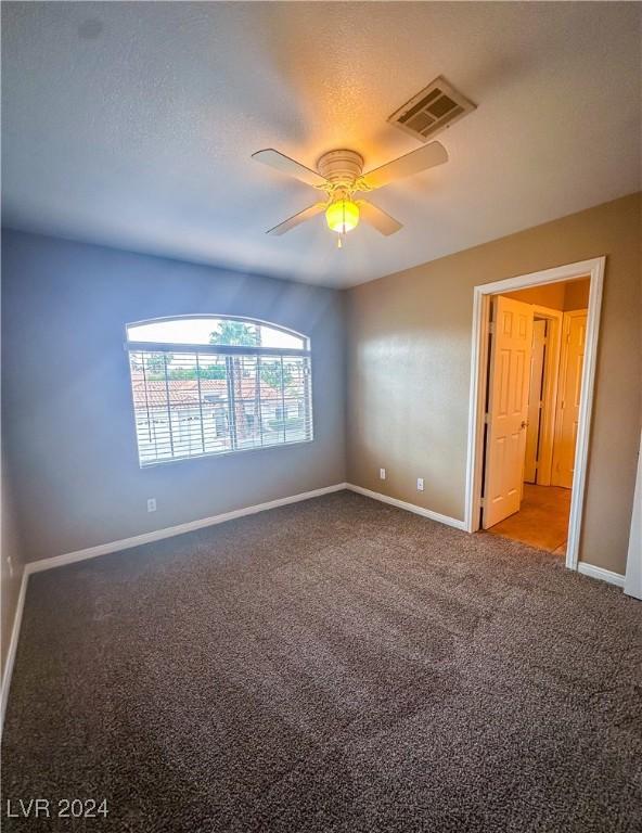 carpeted spare room featuring ceiling fan