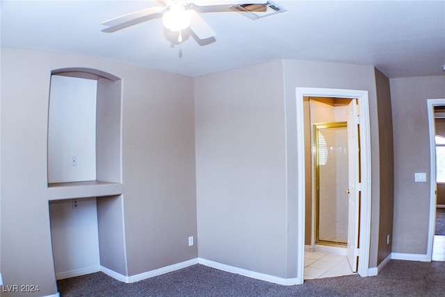 unfurnished bedroom with ceiling fan, ensuite bathroom, and light carpet