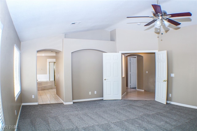 unfurnished room with ceiling fan, light colored carpet, and vaulted ceiling