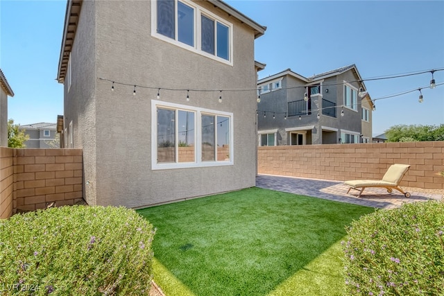 back of property with a patio area and a yard