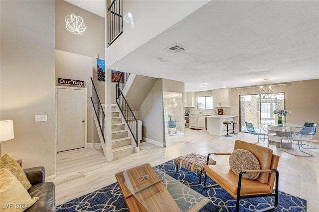 living room with a chandelier and light wood-type flooring