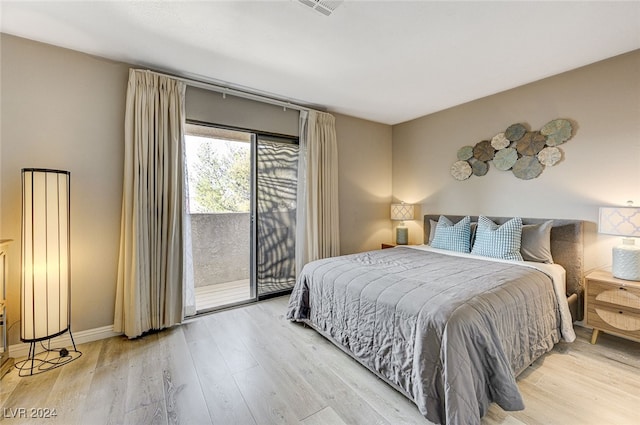 bedroom featuring access to exterior and light hardwood / wood-style flooring