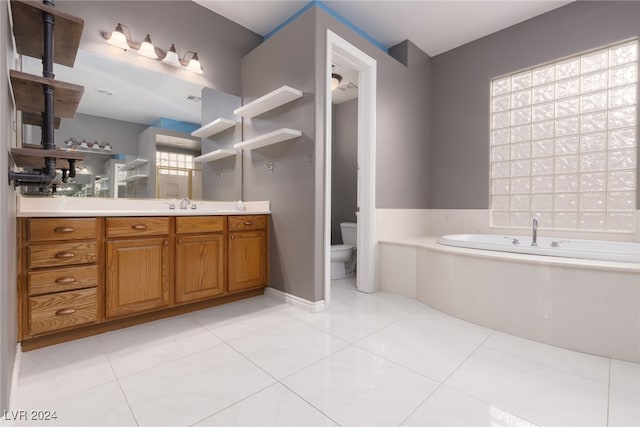 bathroom featuring tile patterned flooring, vanity, toilet, and a tub