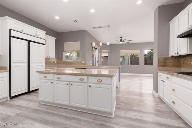 kitchen with white cabinets, ceiling fan, light wood-type flooring, tasteful backsplash, and kitchen peninsula