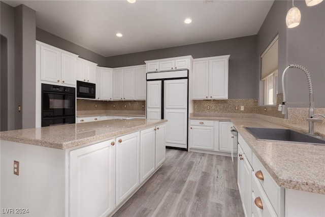 kitchen featuring sink, white cabinets, black appliances, and decorative light fixtures