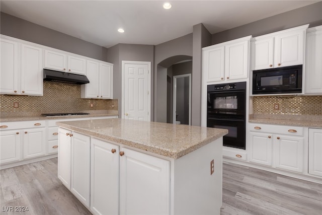 kitchen with black appliances, light hardwood / wood-style floors, white cabinetry, and backsplash