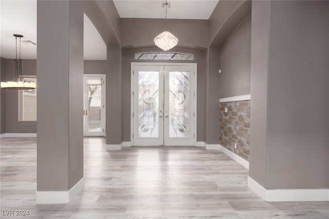 foyer featuring a chandelier, french doors, and light hardwood / wood-style flooring