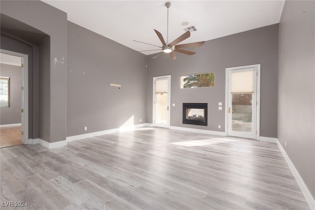 unfurnished living room featuring ceiling fan, plenty of natural light, and light hardwood / wood-style floors