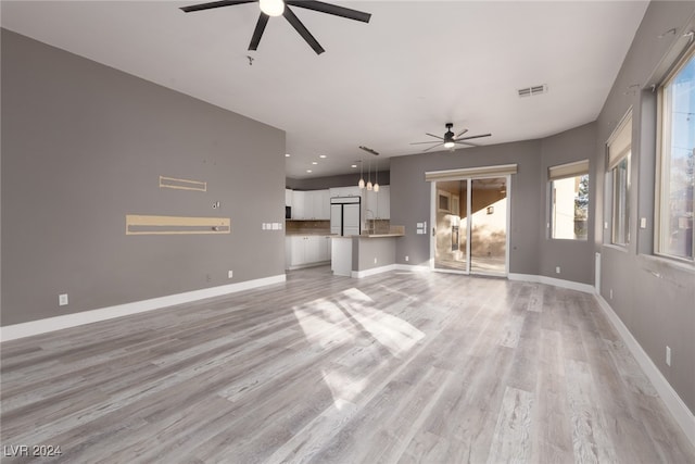 unfurnished living room with ceiling fan and light hardwood / wood-style flooring