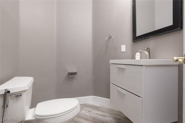 bathroom featuring hardwood / wood-style flooring, vanity, and toilet