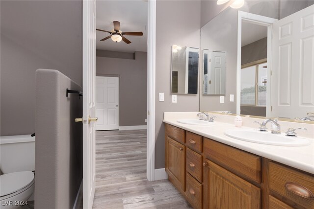 bathroom featuring hardwood / wood-style floors, vanity, toilet, and ceiling fan