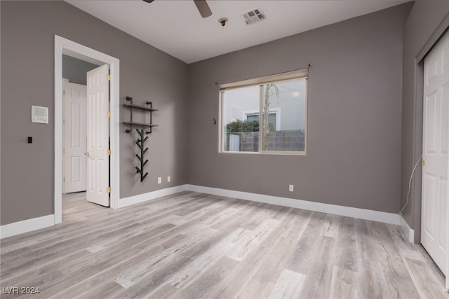 unfurnished bedroom featuring light wood-type flooring, a closet, and ceiling fan