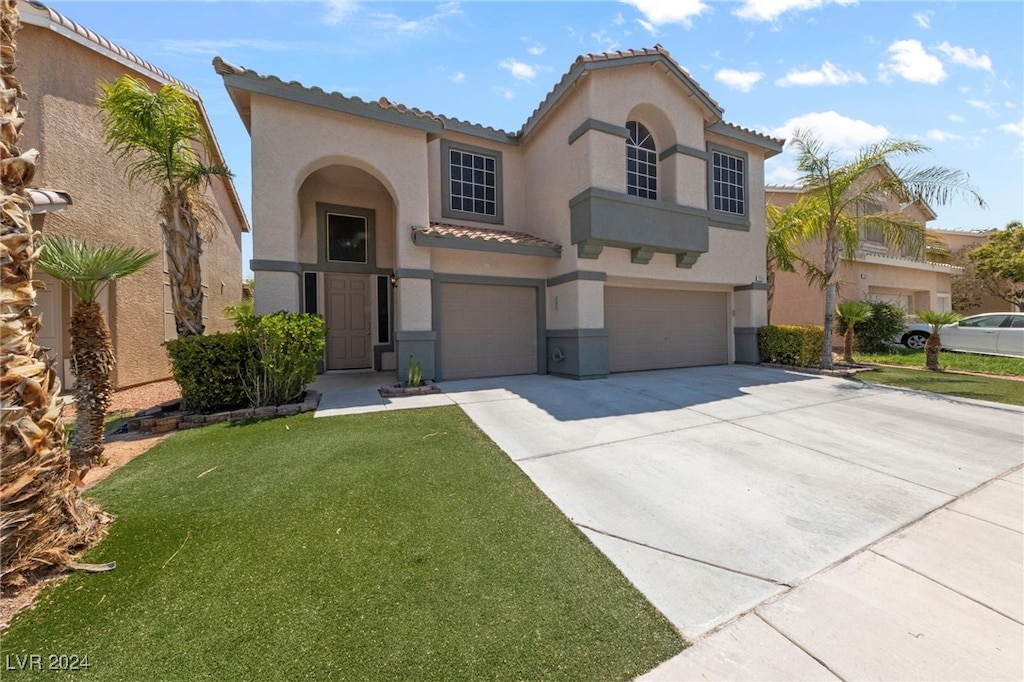 mediterranean / spanish-style home with a garage and a front yard