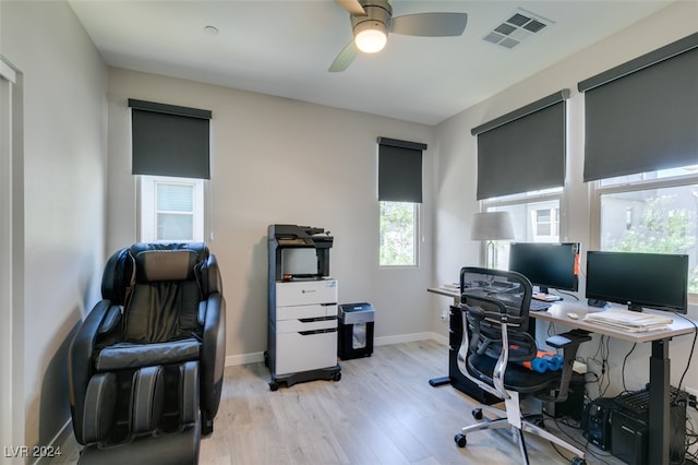 office with light wood-type flooring and ceiling fan