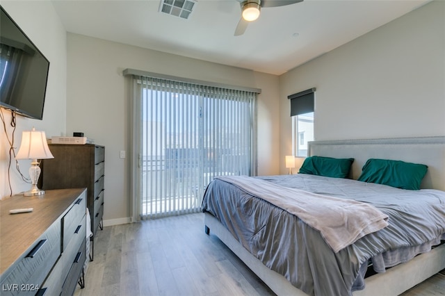 bedroom featuring access to exterior, ceiling fan, light hardwood / wood-style flooring, and multiple windows