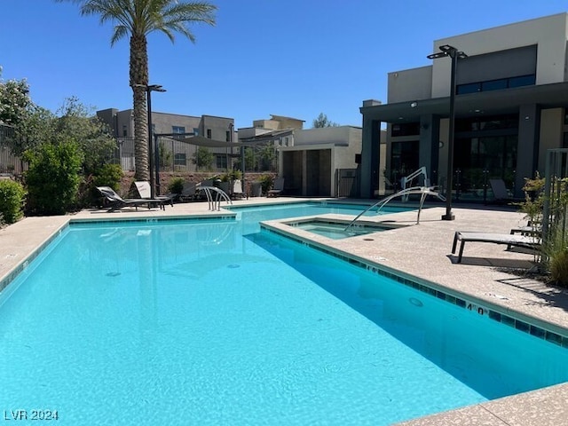 view of swimming pool featuring a patio area and a community hot tub