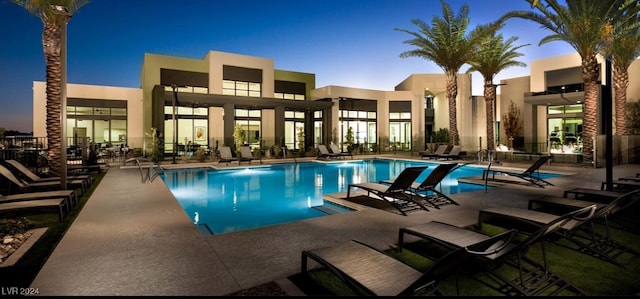 pool at dusk featuring a patio