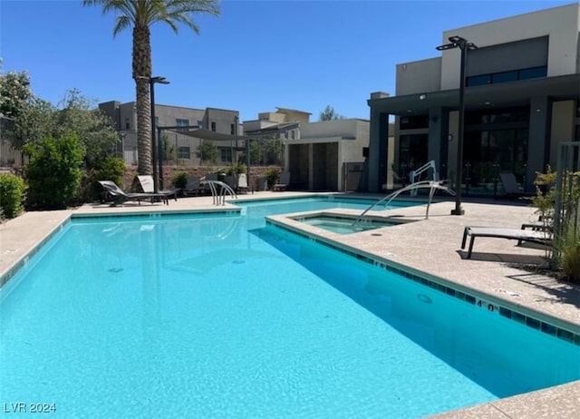 view of swimming pool with a community hot tub and a patio