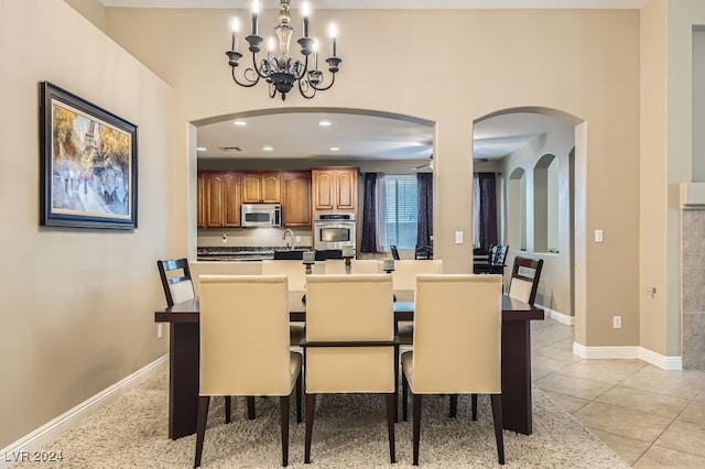 tiled dining space featuring a chandelier and sink