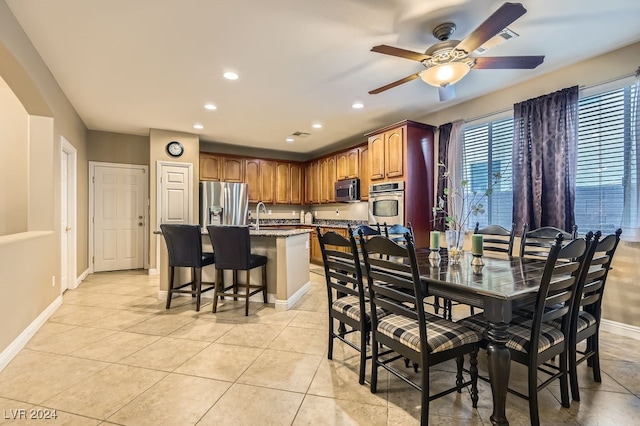 tiled dining area featuring ceiling fan and sink