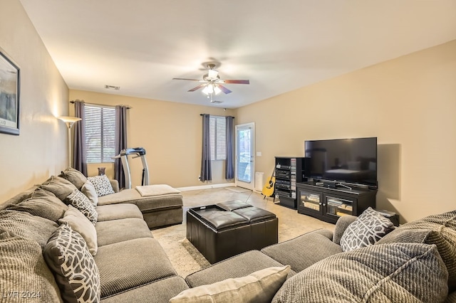 carpeted living room featuring a wealth of natural light and ceiling fan