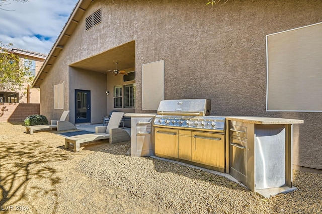 view of patio featuring an outdoor kitchen, ceiling fan, and a grill