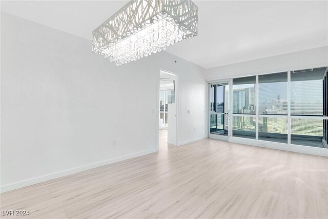 4575 Dean Martin Dr Unit 2211, Las Vegas, NV 89103 - unfurnished living room featuring a chandelier, wood finished floors, and baseboards