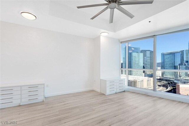 4575 Dean Martin Dr Unit 2211, Las Vegas, NV 89103 - spare room featuring wood finished floors, healthy amount of natural light, ceiling fan, expansive windows, and a view of skyline
