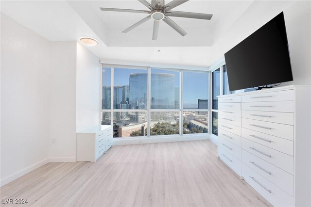 4575 Dean Martin Dr Unit 2211, Las Vegas, NV 89103 - unfurnished bedroom featuring light wood finished floors, expansive windows, baseboards, and ceiling fan
