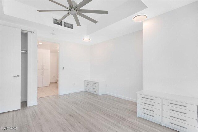 4575 Dean Martin Dr Unit 2211, Las Vegas, NV 89103 - unfurnished bedroom with light wood-style flooring, a raised ceiling, and baseboards