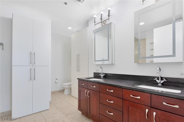 4575 Dean Martin Dr Unit 2211, Las Vegas, NV 89103 - bathroom featuring double vanity, toilet, tile patterned flooring, and baseboards