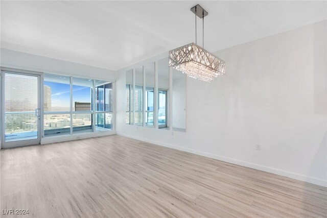 4575 Dean Martin Dr Unit 2211, Las Vegas, NV 89103 - unfurnished room with light wood-type flooring, a chandelier, and baseboards