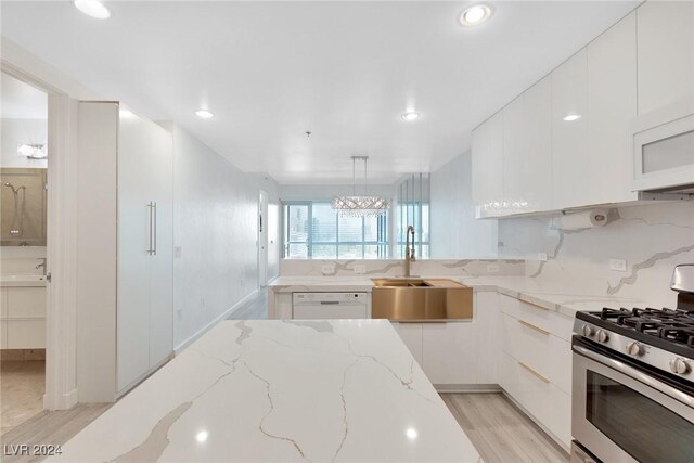 4575 Dean Martin Dr Unit 2211, Las Vegas, NV 89103 - kitchen with white appliances, a sink, white cabinetry, light wood finished floors, and modern cabinets
