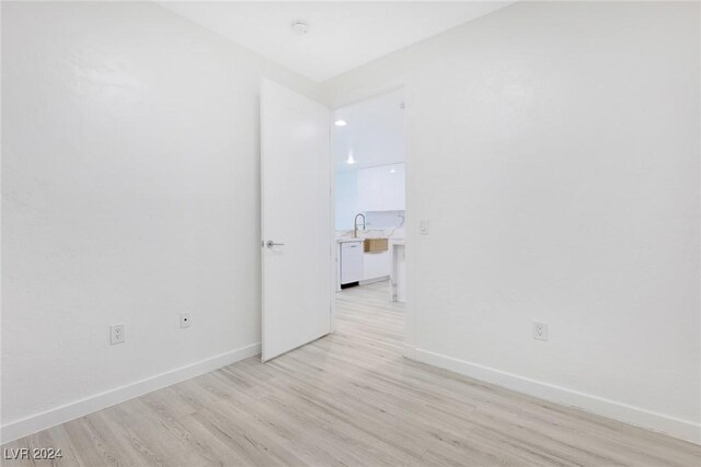 4575 Dean Martin Dr Unit 2211, Las Vegas, NV 89103 - empty room with light wood-style flooring, baseboards, a sink, and a smoke detector