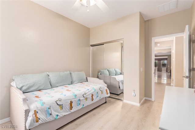 bedroom with ceiling fan, a closet, and light hardwood / wood-style floors