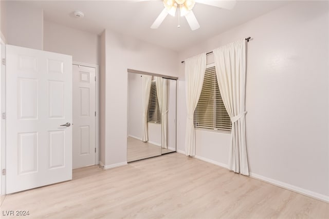 unfurnished bedroom with a closet, light hardwood / wood-style floors, and ceiling fan