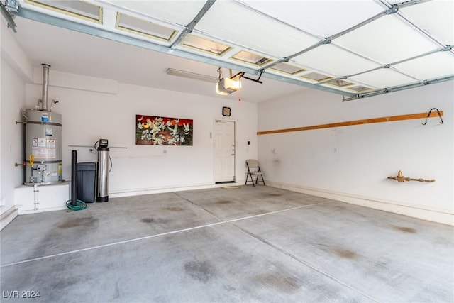 garage with strapped water heater and a garage door opener