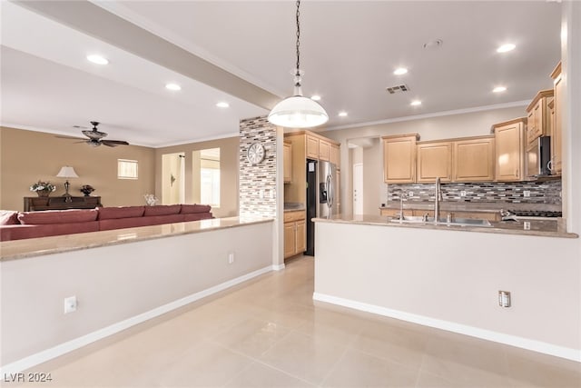 kitchen with sink, stainless steel appliances, hanging light fixtures, tasteful backsplash, and light brown cabinetry