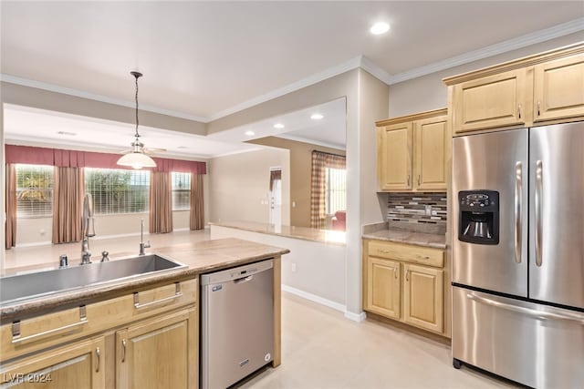 kitchen with plenty of natural light, ornamental molding, sink, and appliances with stainless steel finishes