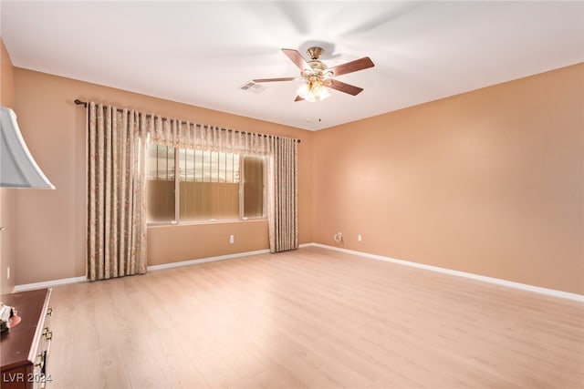 empty room with ceiling fan and light hardwood / wood-style flooring