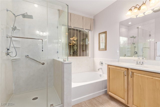 bathroom with hardwood / wood-style floors, vanity, and independent shower and bath