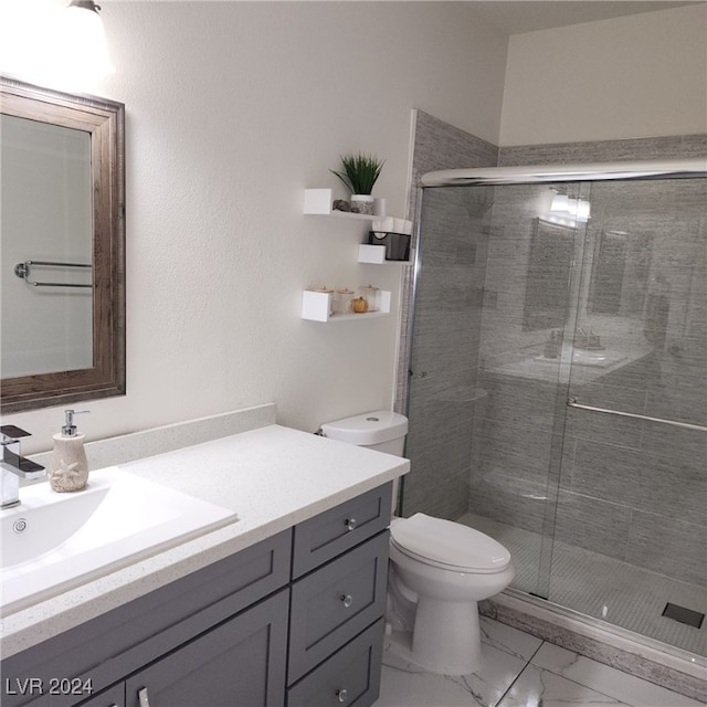 bathroom featuring vanity, toilet, and a shower with shower door