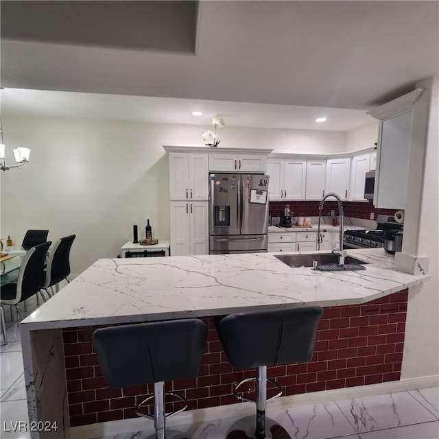 kitchen with pendant lighting, a breakfast bar, white cabinets, kitchen peninsula, and stainless steel appliances