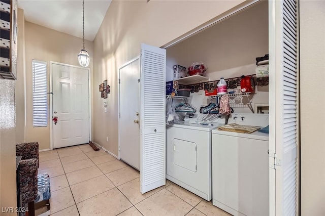 laundry area with washing machine and clothes dryer and light tile patterned floors