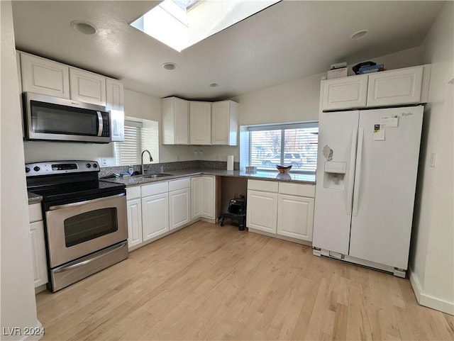 kitchen with light wood-style flooring, appliances with stainless steel finishes, a sink, and white cabinetry