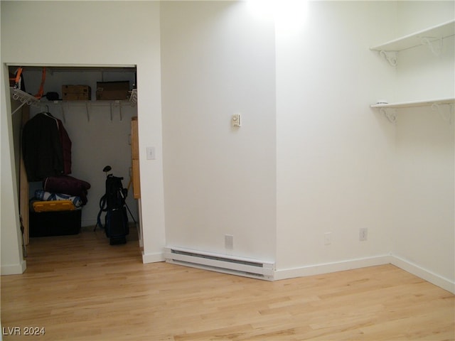 laundry room featuring light hardwood / wood-style flooring and a baseboard heating unit