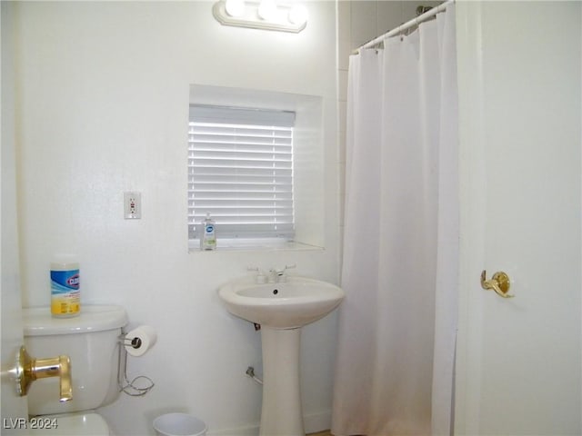 bathroom with a shower with curtain and toilet