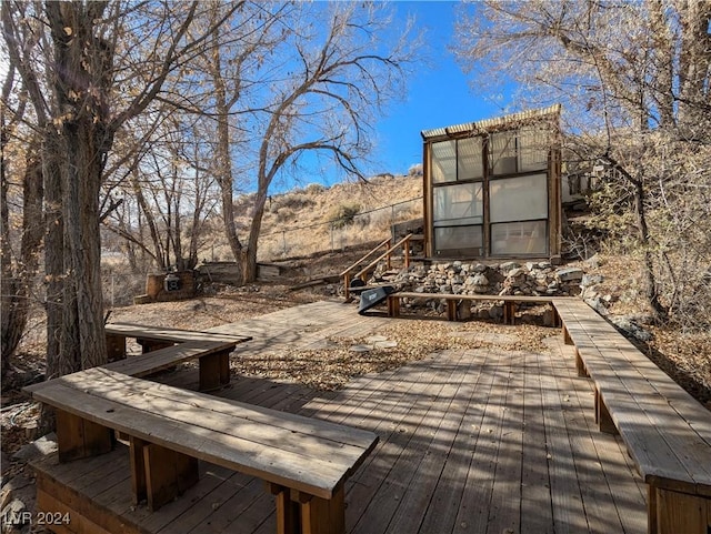 view of community with an outbuilding, a deck with mountain view, and a greenhouse