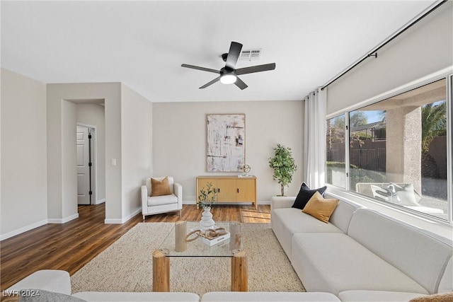 living room featuring ceiling fan and dark wood-type flooring